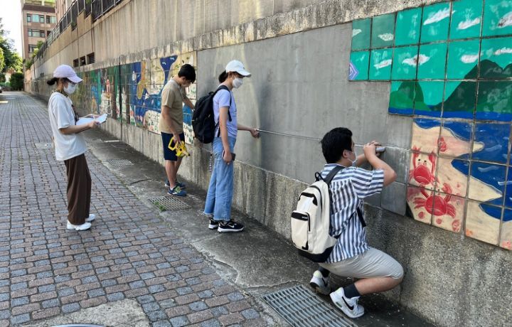 圖/中華大學景觀系學生進行牆面測繪，準備用馬賽克磚拼貼畫作。