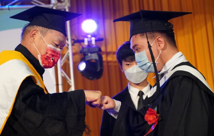圖/中華大學管理學院院長裴文為畢業生撥穗後，擊拳慶祝。