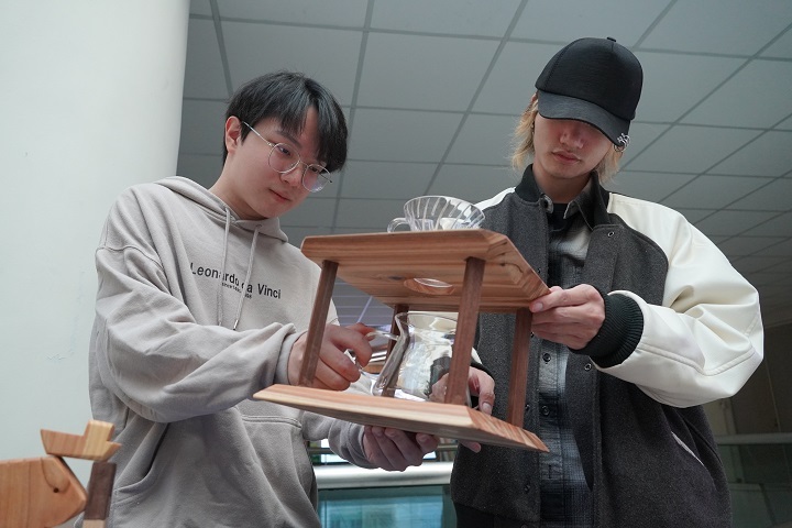 圖／光電系的學生陳亮穎（左）、董建呈（右）首次透過課程學習手作木工，覺得新鮮又有趣。