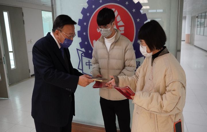 圖/中華大學校長劉維琪(左)對希望翱翔計畫同學親手絹印紅包春聯發送給師長的用心很感動,並當場回贈巧克力祝福同學在兔年都能有很好的發展。