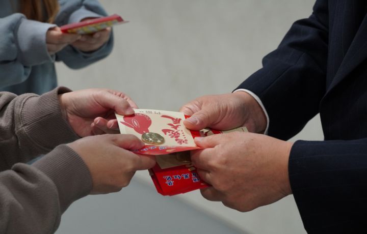 圖/人事室主任林錦煌指出,50元硬幣是經過學校土地公加持過的錢母。