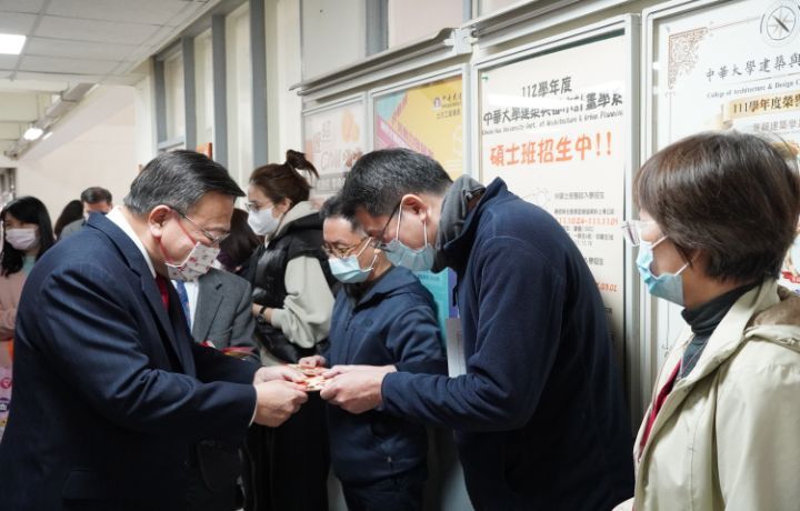 圖/校長劉維琪親自送上50元硬幣錢母和大樂透彩券,向所有教職員拜年。
