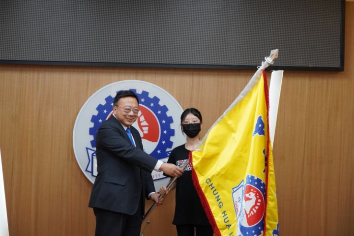 圖/中華大學校長劉維琪授旗給國際志工團團長林苡潔，祝福行程順利平安。