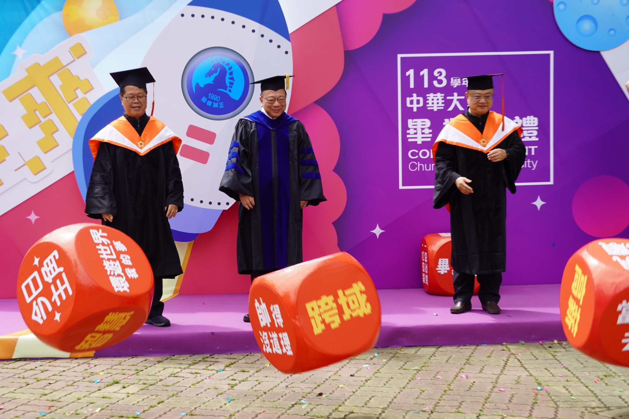 圖／中華大學校長及兩位副校長分別為畢業生擲出「高薪、我要當老闆、人生勝利家」三種未來方向
