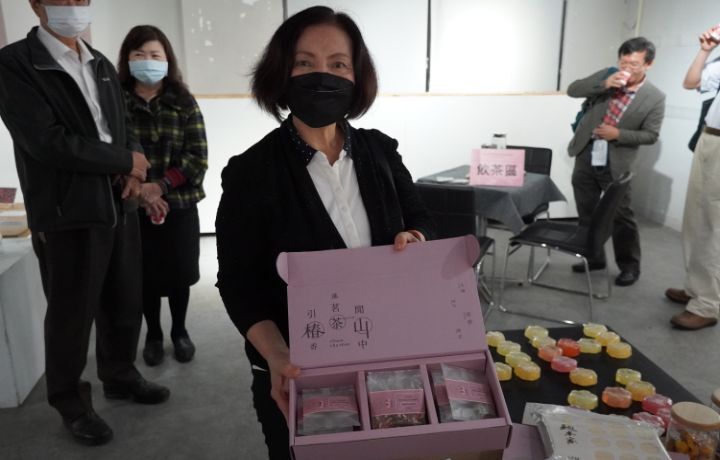 圖/東鄉事業有限公司董事長陳惠珠向與會貴賓展示茶花周邊商品。