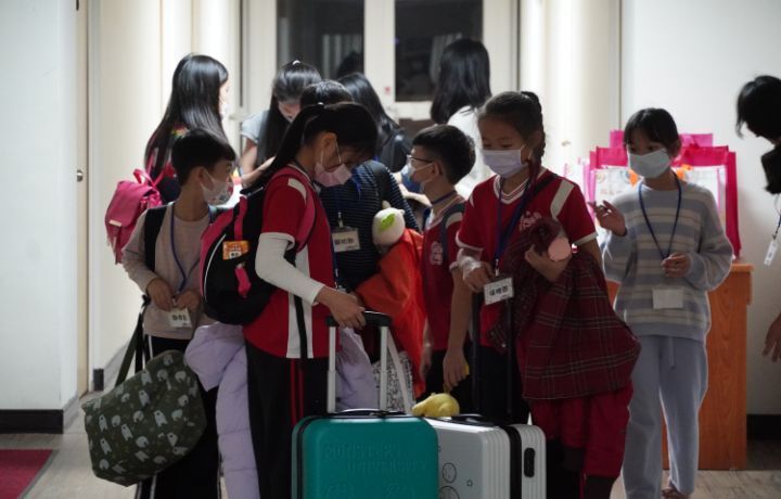 圖/南埔國小學童提著行李夜宿中華大學觀光學院實習旅館。