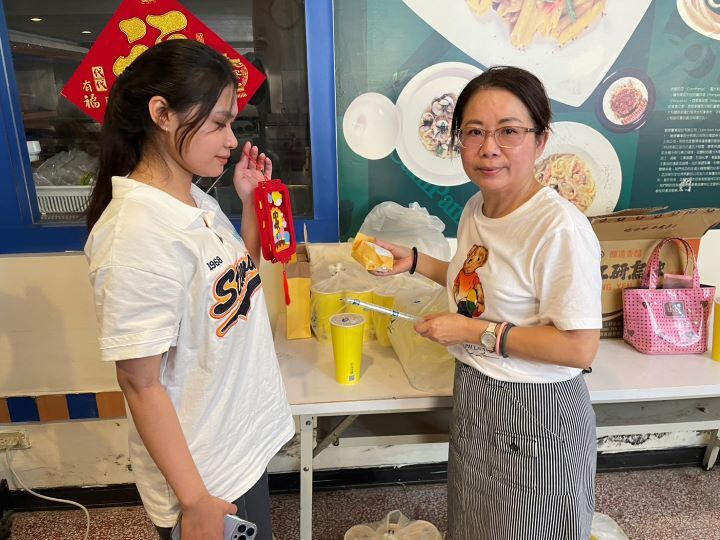 圖/國際專修部學務組長莊英慧(右)為學生送上蛋黃酥與飲料,讓異鄉學子感受滿滿溫暖。