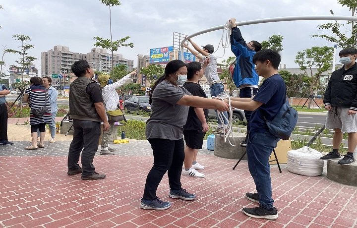 圖/同學在老師的指導下參與實作，分工合作綁繫垂簾。