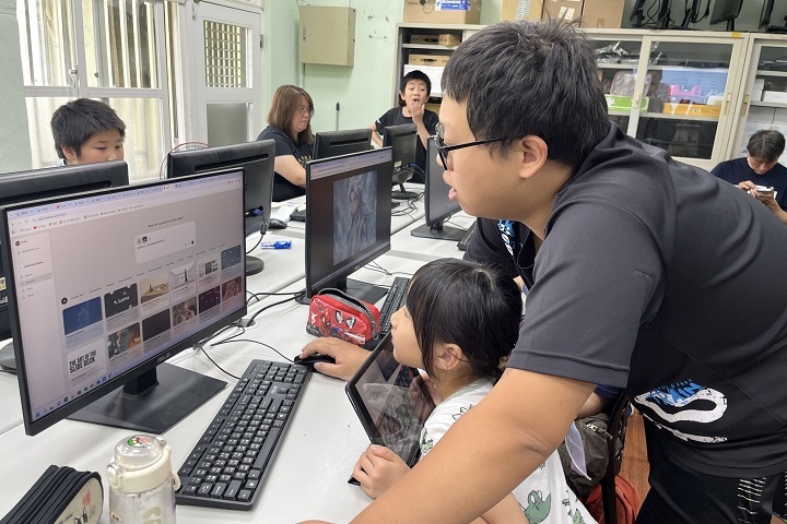 中華大學資工系學生助教一對一引導學童操作 AI 工具，以陪伴式教學拉近科技與孩子的距離。