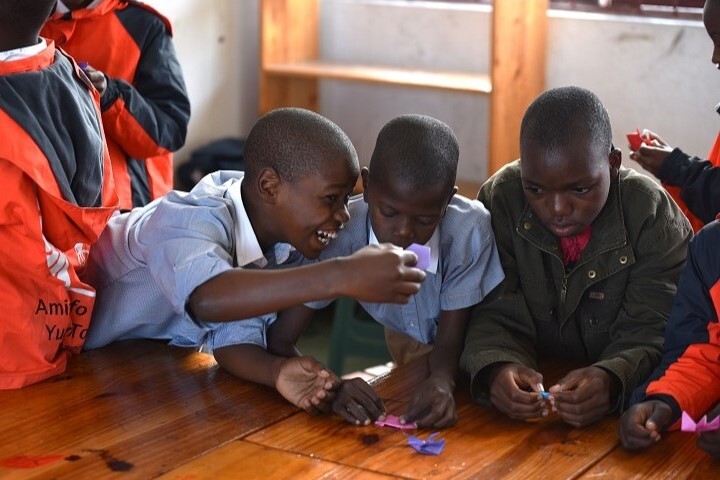 圖／院區的孩子們玩著志工們親手教的青蛙摺紙遊戲意猶未盡，口中直喊要繼續玩sapo（葡萄牙文“青蛙”意思） 